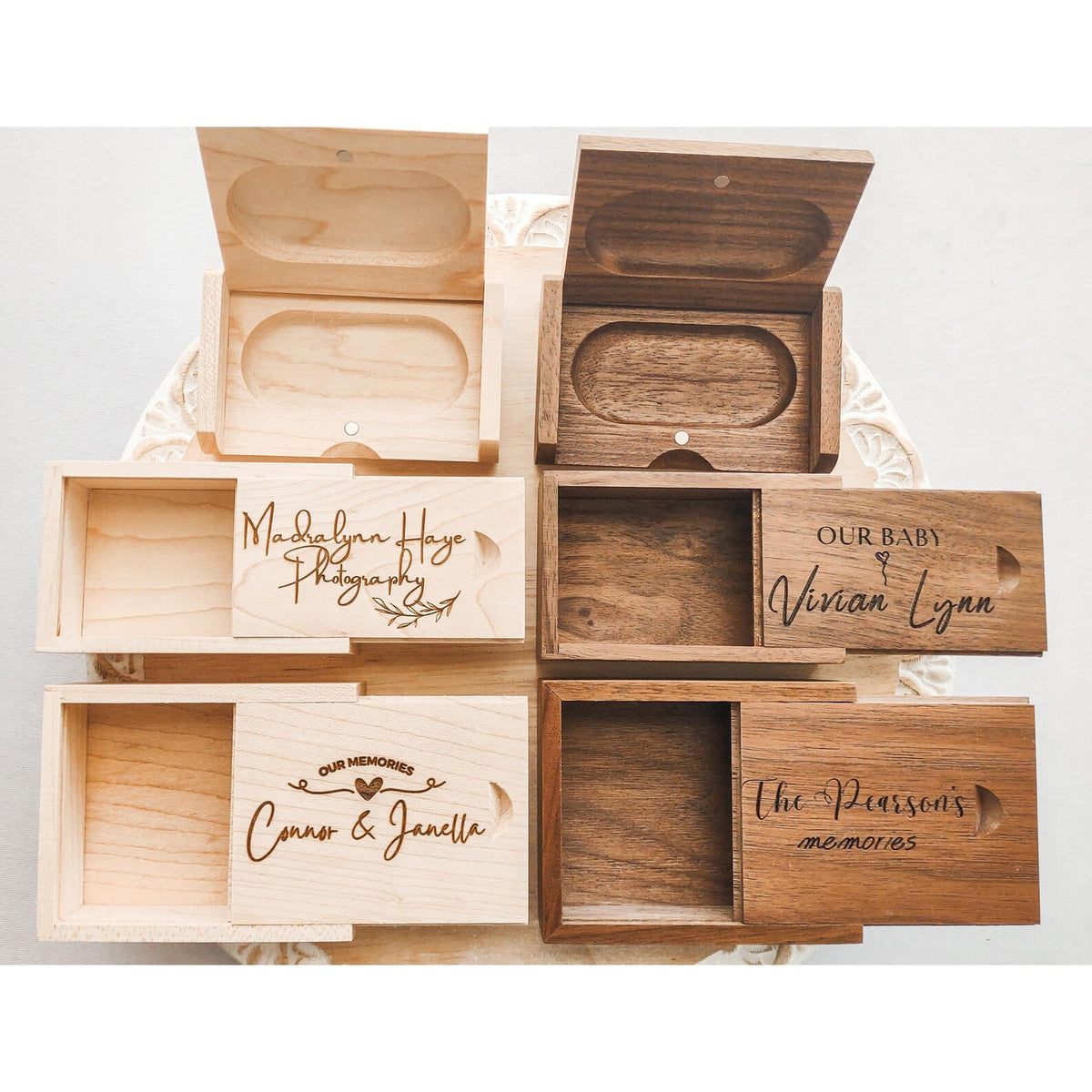 Six personalized wooden keepsake boxes in two wood tones, shown open and closed with custom laser-engraved names on a white lace doily.