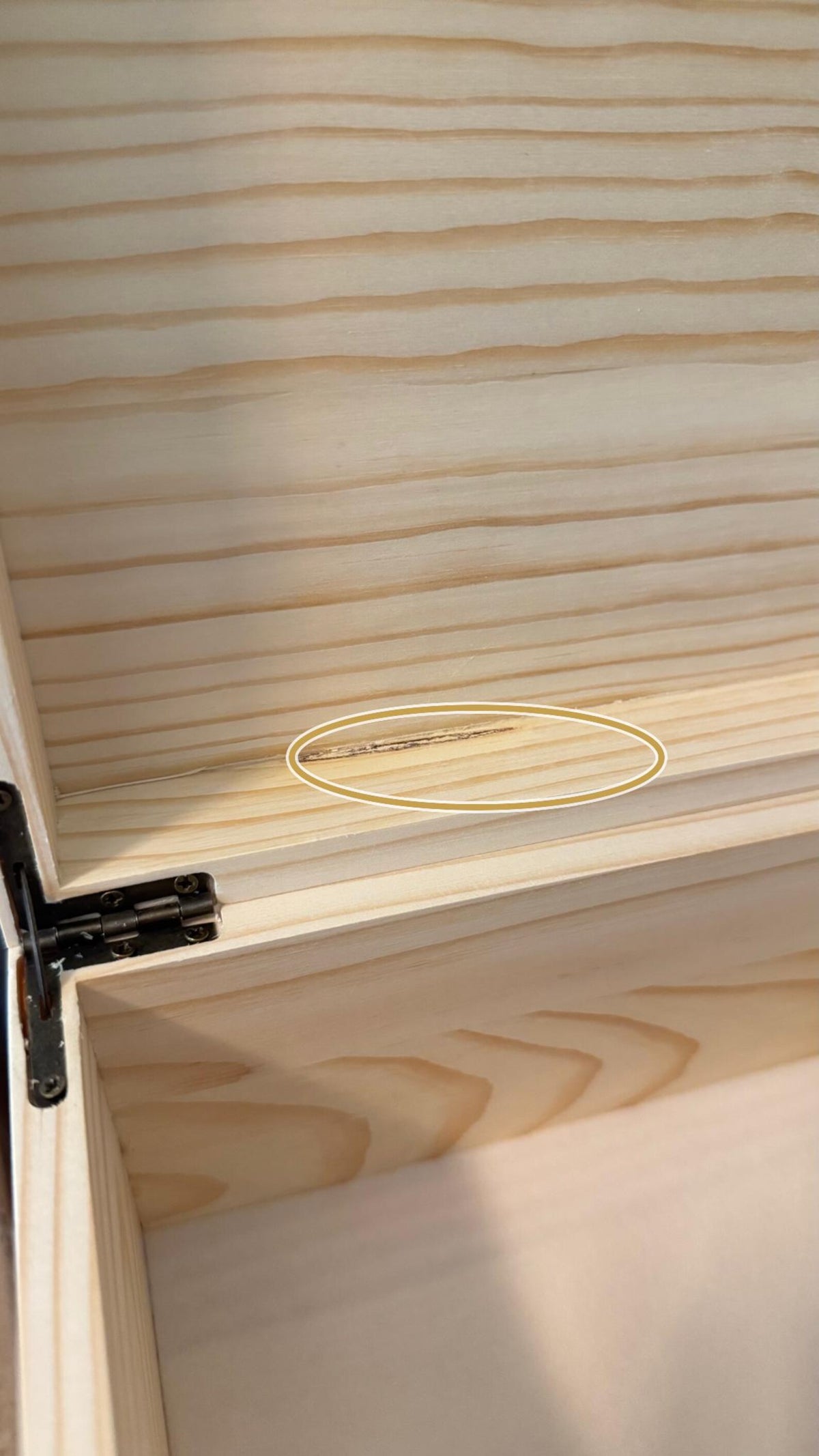 Close-up of a wooden pet keepsake box corner showing natural wood variations and signs of repair
